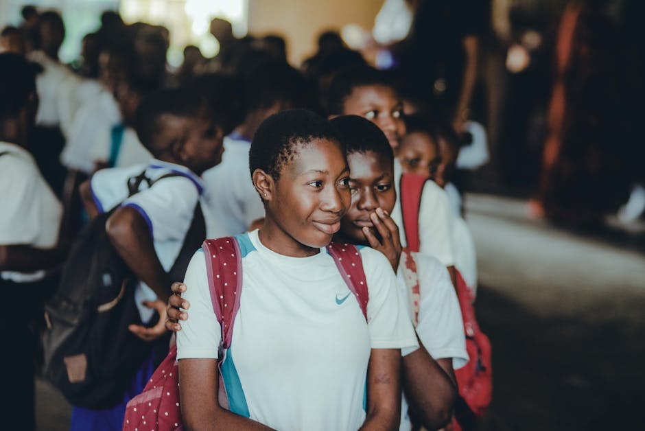 Close-up of students in school uniforms and backpacks indoors. Diverse and educational setting.