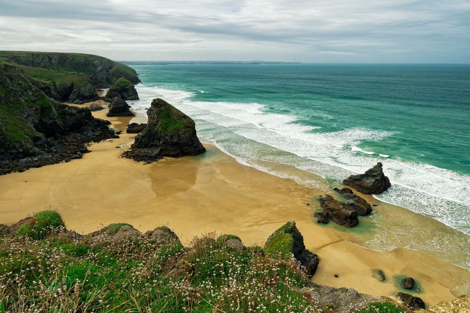 Turquoise zee en gouden strand met kliffen aan de kust van Cornwall
