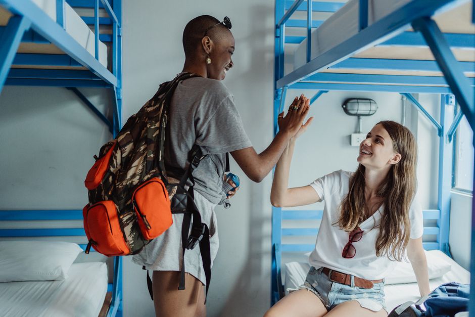 Gemeenschappelijke ruimte van een hostel met reizigers en banken