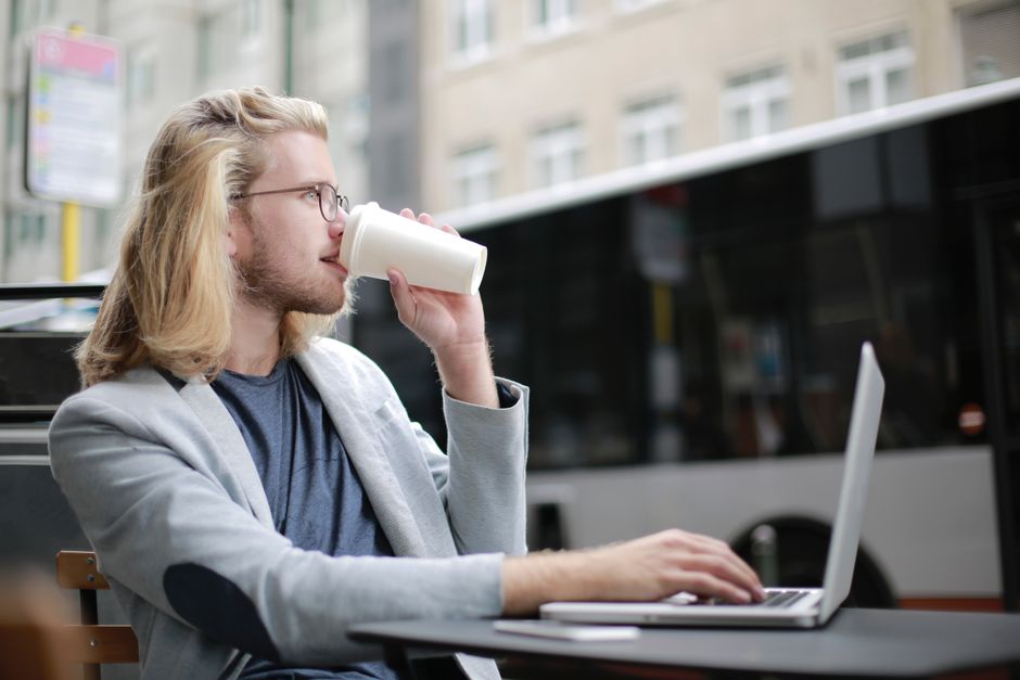 Persoon werkt op een laptop in een café tijdens een verblijf in het VK
