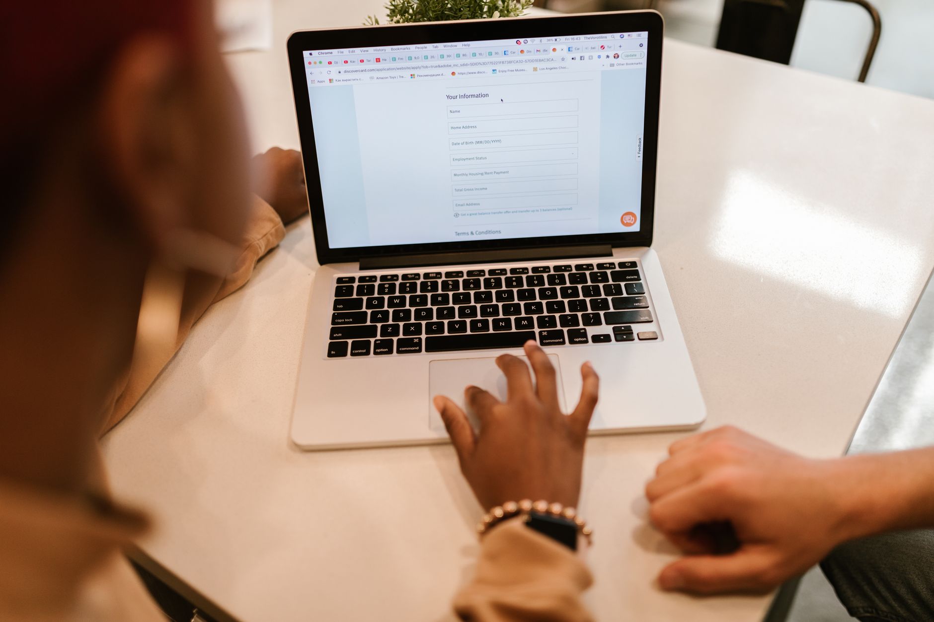Reiziger vult een digitale reisautorisatie in op een laptop met een paspoort ernaast