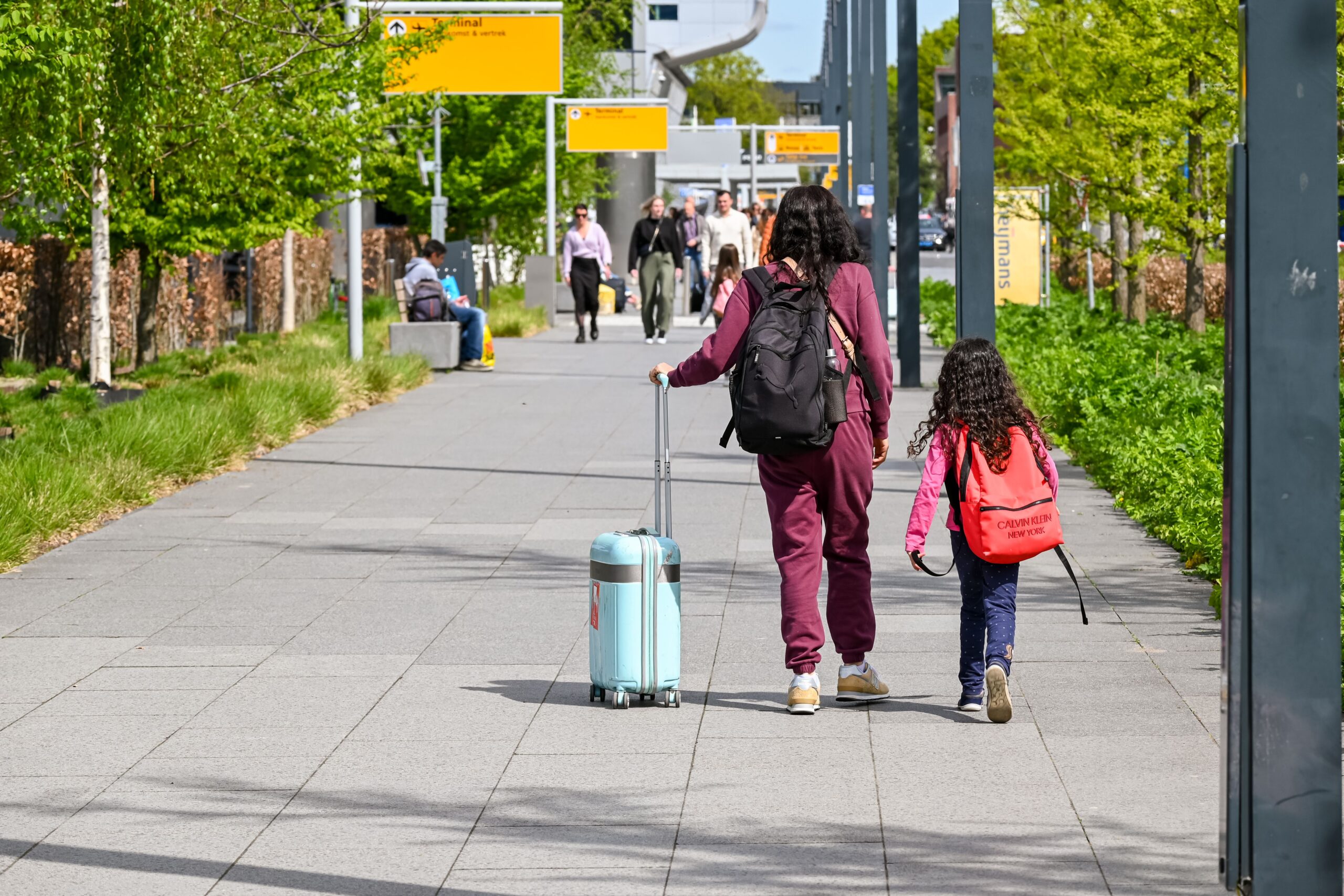 Moeder en dochter lopen met koffers buiten op weg naar hun reis naar Engeland